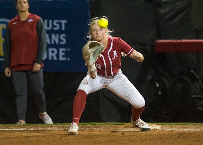 Alabama Crimson Tide utility Lauren Esman (9) makes a catch at first for an out during a quarterfinal game against the Arkansas Razorbacks in the SEC Softball Tournament.